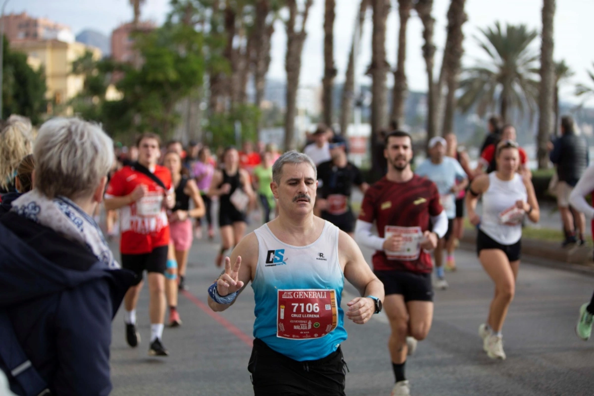 Loper van het Cardenasports-team zwaait tijdens de Marathon van Málaga