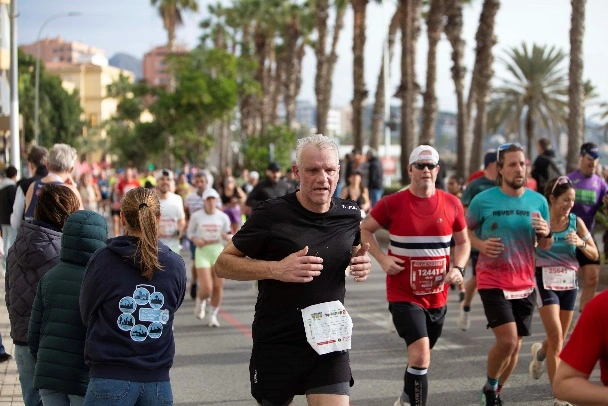Loper met startnummer houdt een gecontroleerd tempo aan tijdens een wedstrijd in Málaga